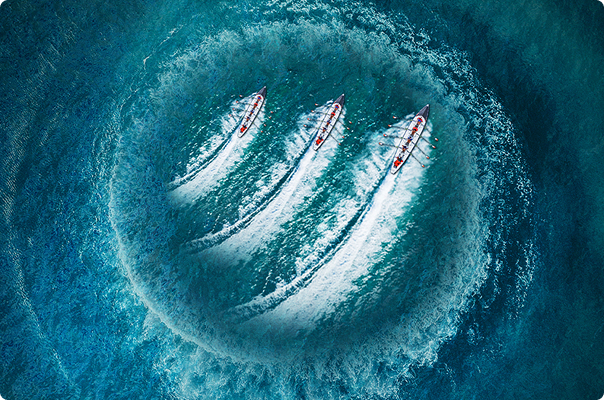 Aerial view of boats leaving wake patterns in blue water